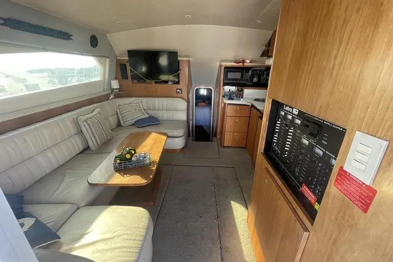 Slide: The Image of 1999 Luhrs Tournament 360 yacht interior with cozy seating, TV, and kitchenette. - 8