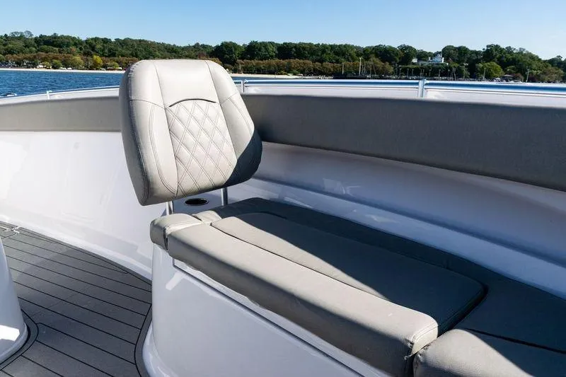 Slide: The Image of 2024 Sportsman Open 322 Center Console boat with cushioned seating, on a sunny day. - 13