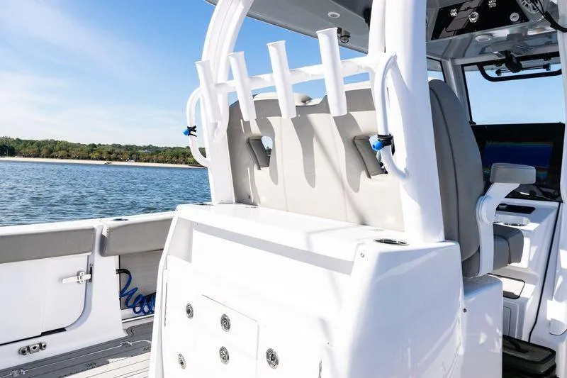 Slide: The Image of 2024 Sportsman Open 322 Center Console boat detail with rod holders and radar, on a sunny day. - 29