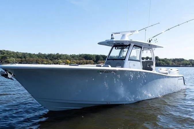 Slide: The Image of 2024 Sportsman Open 322 Center Console boat with Yamaha engines on calm water. - 4