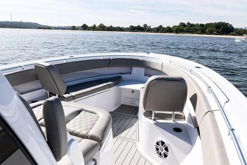Slide: The Image of 2024 Sportsman Open 322 Center Console boat interior with seating, on a calm waterway. - 9