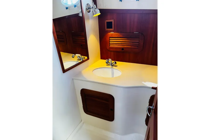 Slide: The Image of Hinckley Picnic Boat MKIII 2012 bathroom with wooden accents and modern sink design. - 17