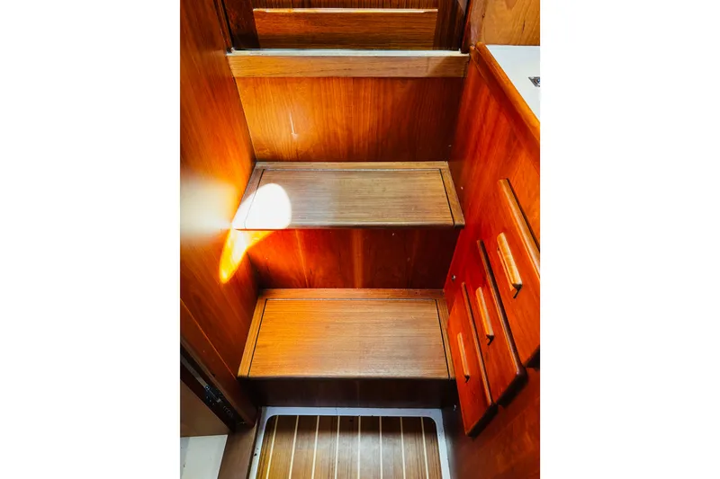 Slide: The Image of Wooden interior stairs of 2012 Hinckley Picnic Boat MKIII, featuring warm tones and cabinetry. - 20