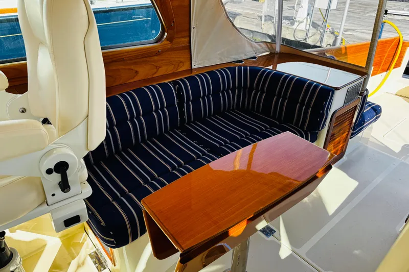 Slide: The Image of Luxurious interior of 2012 Hinckley Picnic Boat MKIII with striped seating and wooden table. - 31