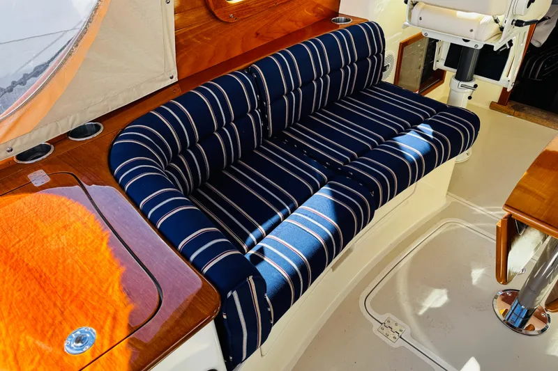 Slide: The Image of 2012 Hinckley Picnic Boat MKIII interior with striped seating and wooden accents. - 35