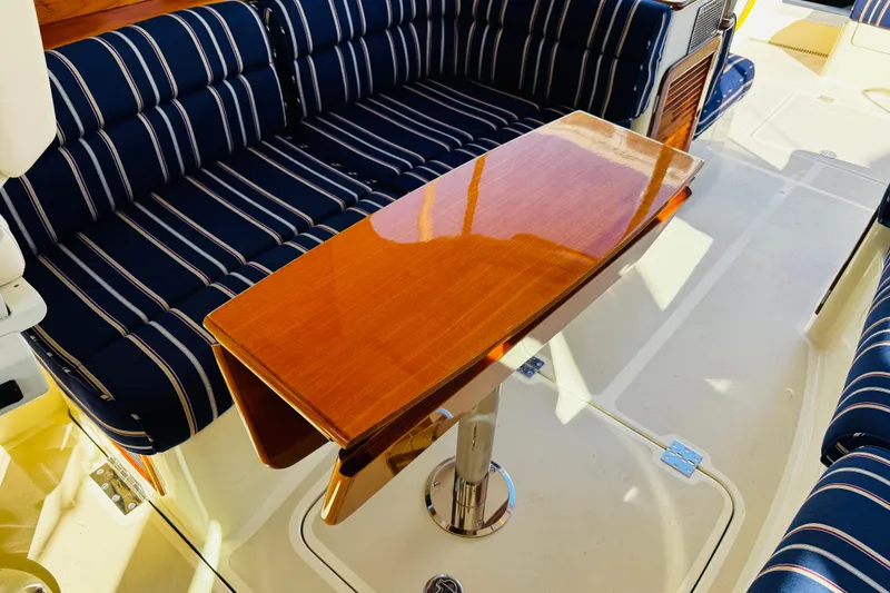 Slide: The Image of Hinckley Picnic Boat MKIII 2012 interior with striped seating and polished wooden table. - 39