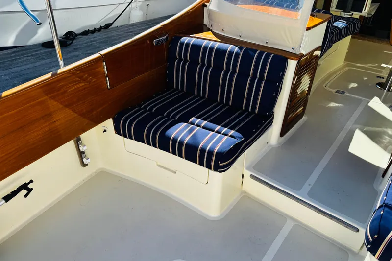 Slide: The Image of 2012 Hinckley Picnic Boat MKIII interior with striped seating and wooden accents. - 42