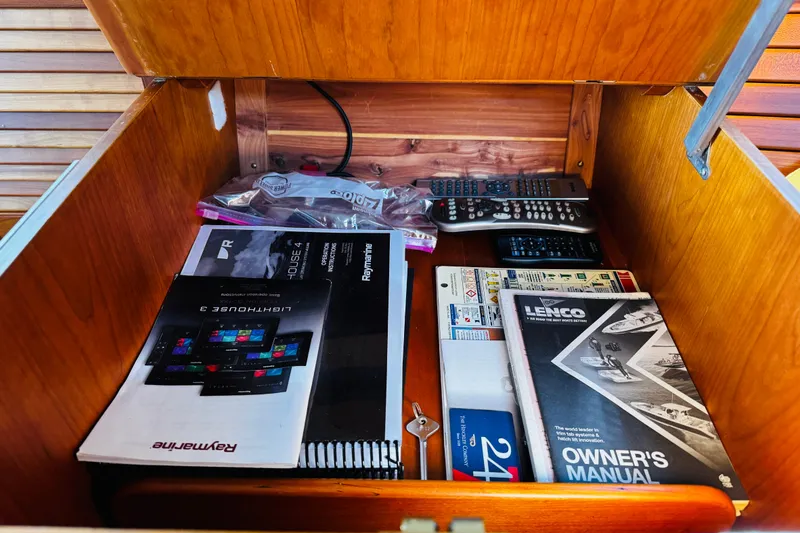 Slide: The Image of Storage compartment in a 2012 Hinckley Picnic Boat MKIII with manuals and remote controls. - 47