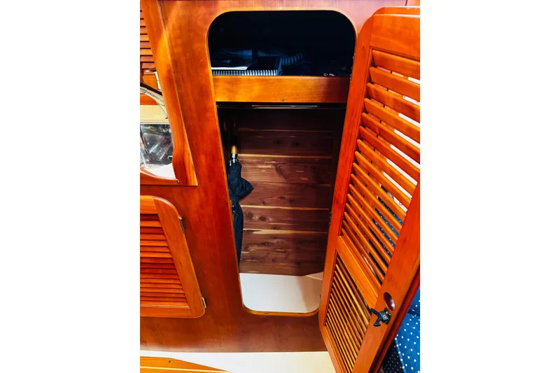 Slide: The Image of Interior of 2012 Hinckley Picnic Boat MKIII with wooden cabinetry and louvered doors. - 7