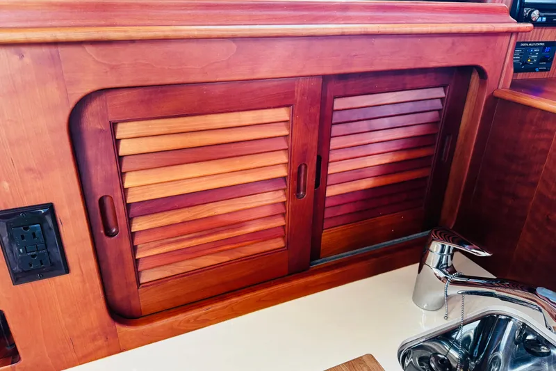 Slide: The Image of Hinckley Picnic Boat MKIII 2012 interior with wooden cabinet and stainless steel sink. - 13