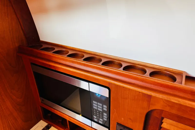 Slide: The Image of Hinckley Picnic Boat MKIII 2012 interior with wooden cup holders and microwave. - 14