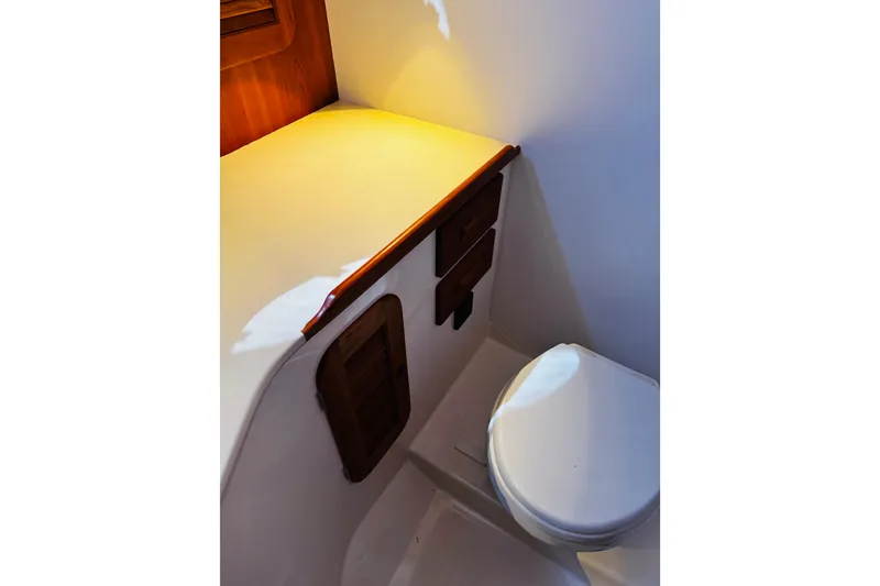 Slide: The Image of 2012 Hinckley Picnic Boat MKIII interior with compact bathroom and wooden cabinetry. - 19