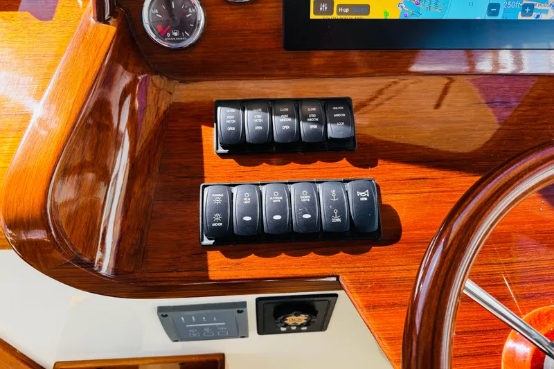 Slide: The Image of Control panel of a 2012 Hinckley Picnic Boat MKIII with switches and navigation display. - 25