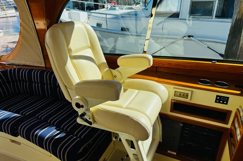 Slide: The Image of Captain's chair and interior of 2012 Hinckley Picnic Boat MKIII, featuring elegant design and wood accents. - 29