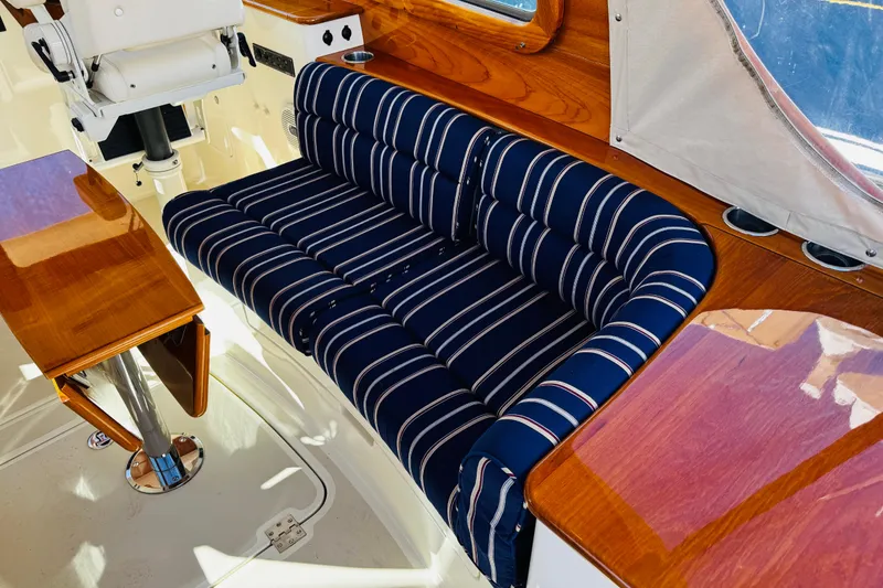 Slide: The Image of 2012 Hinckley Picnic Boat MKIII interior with striped seating and polished wood finish. - 32