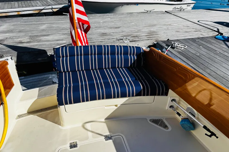 Slide: The Image of Hinckley Picnic Boat MKIII 2012 with striped seating and American flag at dock. - 40