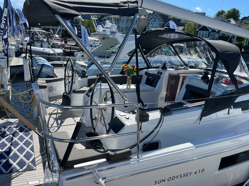 Slide: The Image of 2024 Jeanneau Sun Odyssey 410 sailboat docked, featuring dual steering wheels and sleek design. - 1