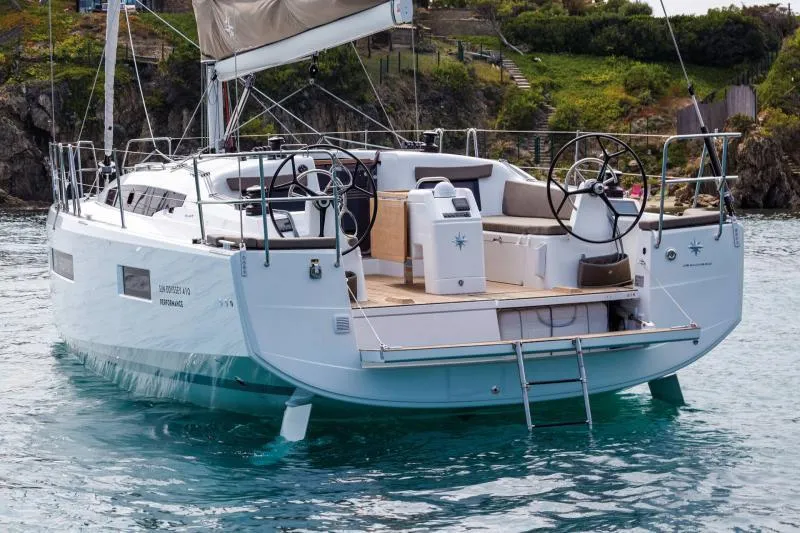 Slide: The Image of 2024 Jeanneau Sun Odyssey 410 sailboat on water, featuring dual steering wheels and spacious deck. - 13