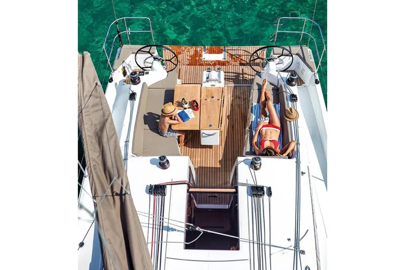 Slide: The Image of 2024 Jeanneau Sun Odyssey 410 yacht deck with people relaxing in the sun. - 15