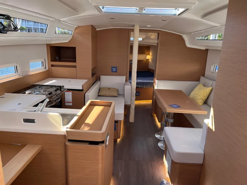 Slide: The Image of Interior of 2024 Jeanneau Sun Odyssey 410 sailboat, featuring modern wood finish and cozy seating. - 16