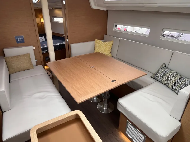 Slide: The Image of 2024 Jeanneau Sun Odyssey 410 interior with modern seating and wooden table. - 18