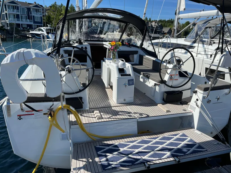 Slide: The Image of 2024 Jeanneau Sun Odyssey 410 sailboat with dual steering wheels, docked in a marina. - 2