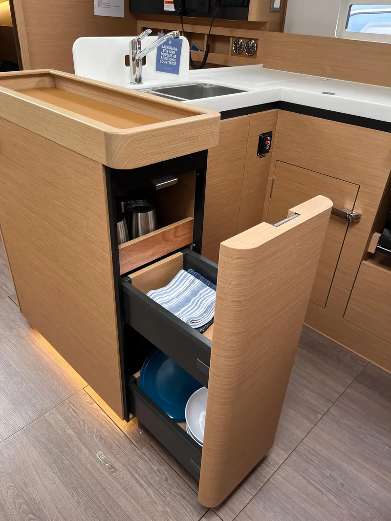 Slide: The Image of 2024 Jeanneau Sun Odyssey 410 kitchen with modern cabinetry and pull-out storage drawers. - 21