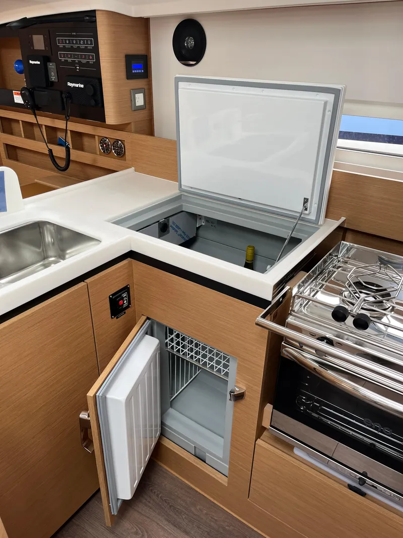 Slide: The Image of 2024 Jeanneau Sun Odyssey 410 yacht kitchen with open fridge, freezer, and stove. - 22