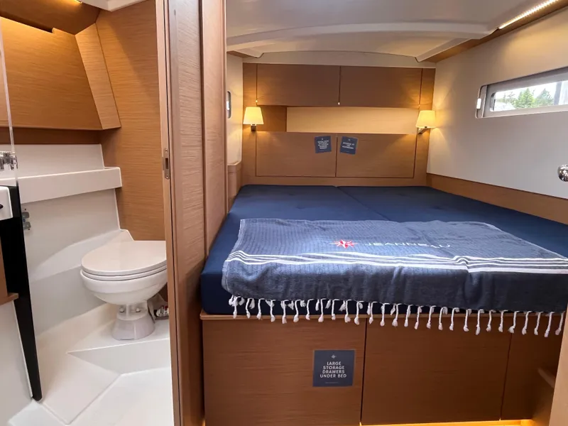 Slide: The Image of 2024 Jeanneau Sun Odyssey 410 cabin interior with bed, bathroom, and modern lighting. - 25