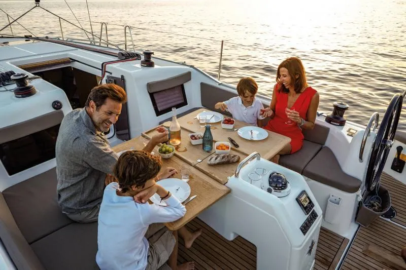 Slide: The Image of Family dining on Jeanneau Sun Odyssey 410 yacht, 2024 model, enjoying a meal at sunset. - 27