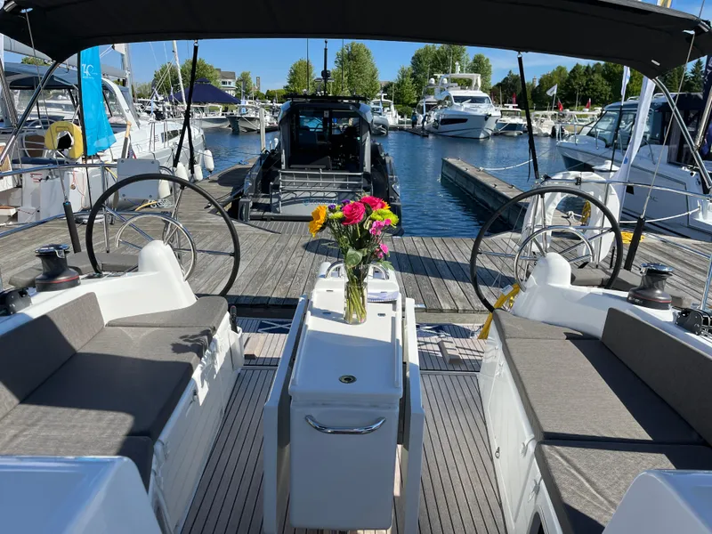 Slide: The Image of 2024 Jeanneau Sun Odyssey 410 sailboat interior with dual steering wheels and floral centerpiece. - 3