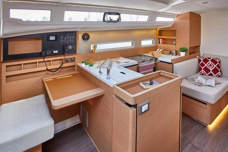 Slide: The Image of 2024 Jeanneau Sun Odyssey 410 interior with modern kitchen, seating area, and navigation station. - 30