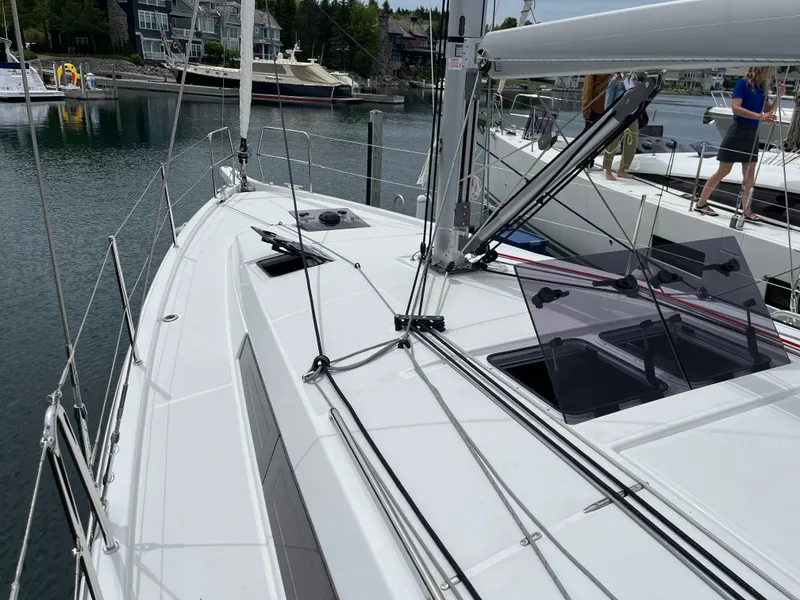 Slide: The Image of 2024 Jeanneau Sun Odyssey 410 sailboat docked in a marina, showcasing sleek deck design. - 5