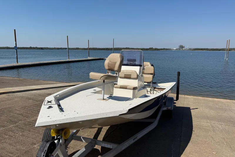 Slide: The Image of 2018 Xpress H20B Bay boat on trailer by a lake under clear blue sky. - 28