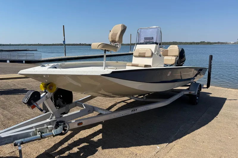 Slide: The Image of 2018 Xpress H20B Bay boat on trailer by the water. - 29