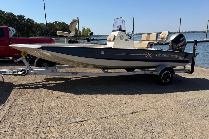 Slide: The Image of 2018 Xpress H20B Bay boat on trailer by the water. - 31