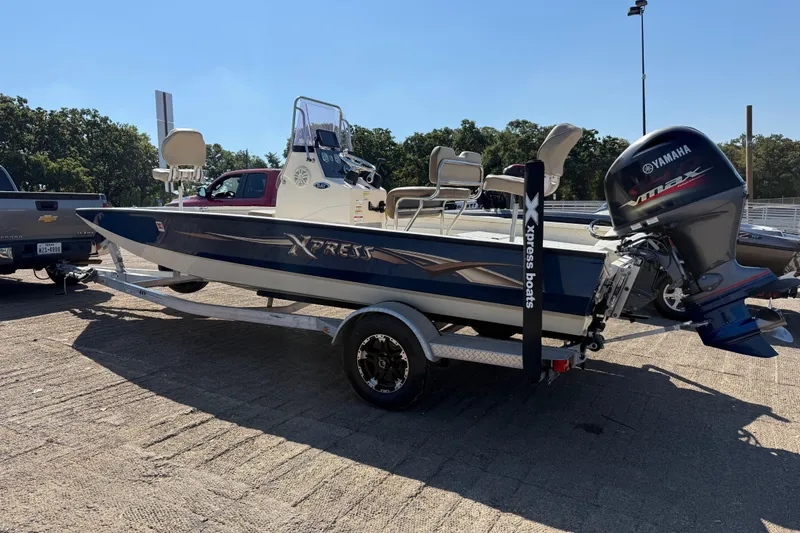 Slide: The Image of 2018 Xpress H20B Bay boat on trailer with Yamaha engine, parked outdoors. - 35