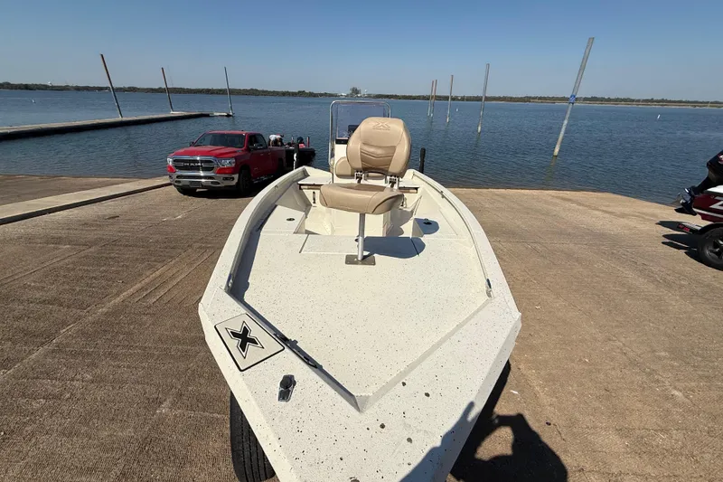 Slide: The Image of 2018 Xpress H20B Bay boat on a ramp near a lake, with a red truck nearby. - 49
