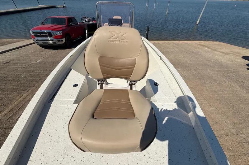 Slide: The Image of 2018 Xpress H20B Bay boat with tan seats at a lakeside dock. - 50