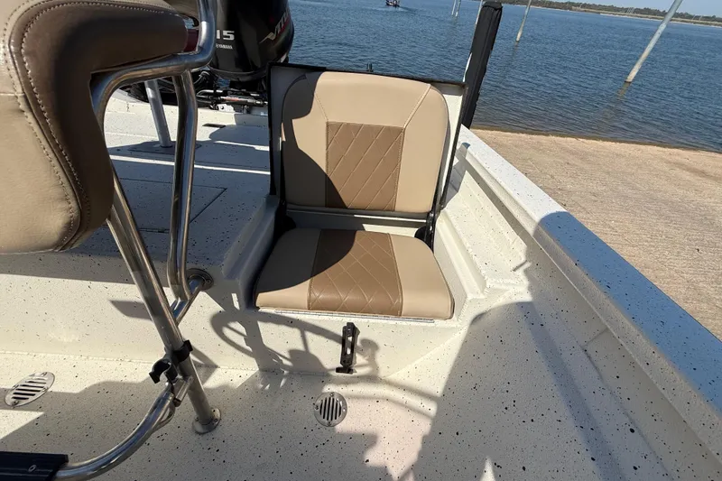 Slide: The Image of 2018 Xpress H20B Bay boat interior with tan seating and Yamaha motor, near water. - 59