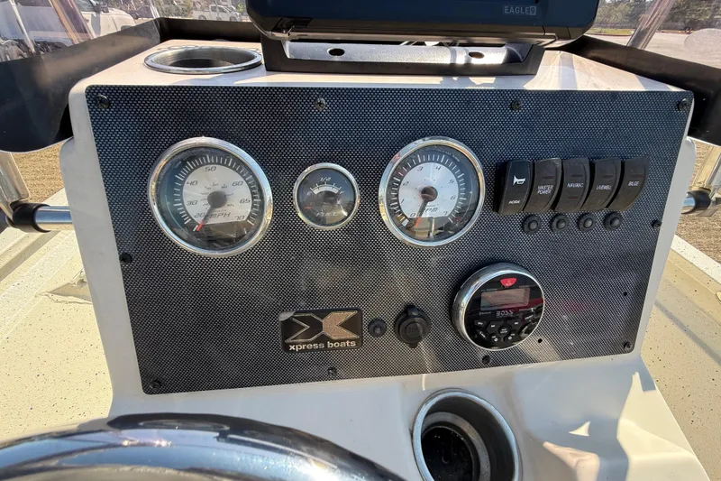 Slide: The Image of 2018 Xpress H20B Bay boat dashboard with gauges and controls. - 64