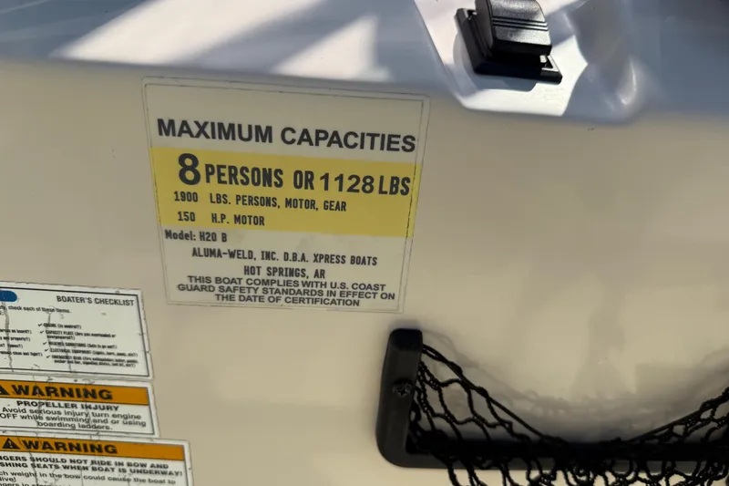 Slide: The Image of 2018 Xpress H20B Bay boat capacity label, max 8 persons or 1128 lbs, 150 HP motor. - 71