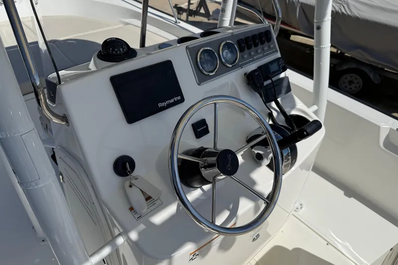 Slide: The Image of 2019 Boston Whaler 190 Montauk boat with covered console in marina setting. - 25