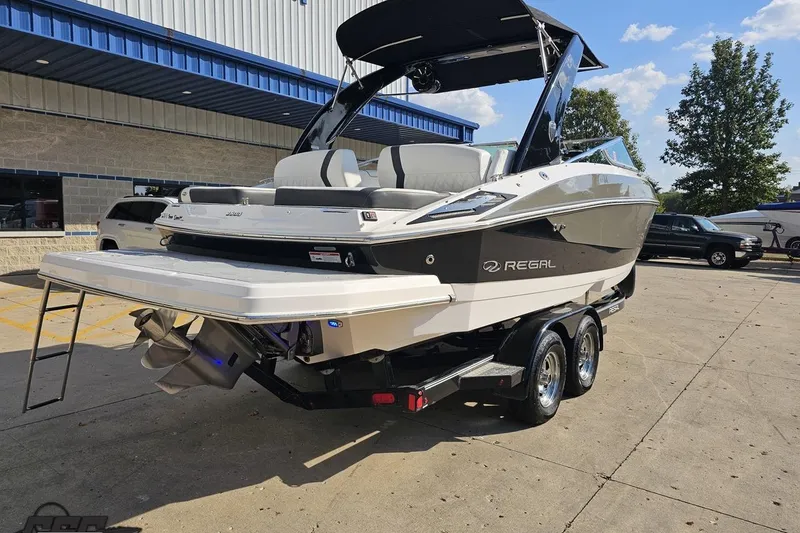 Slide: The Image of 2018 Regal 2500 Bowrider boat on trailer, parked outdoors near a building. - 11