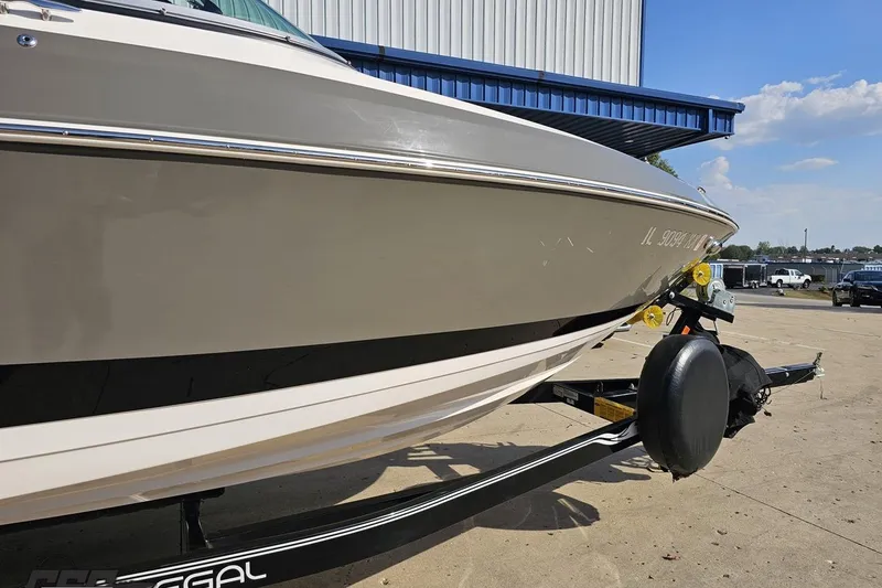 Slide: The Image of 2018 Regal 2500 Bowrider boat on trailer, parked outdoors under blue sky. - 12