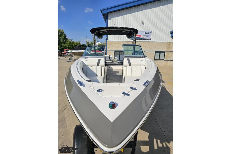 Slide: The Image of 2018 Regal 2500 Bowrider boat with sleek design, parked outdoors under clear sky. - 18