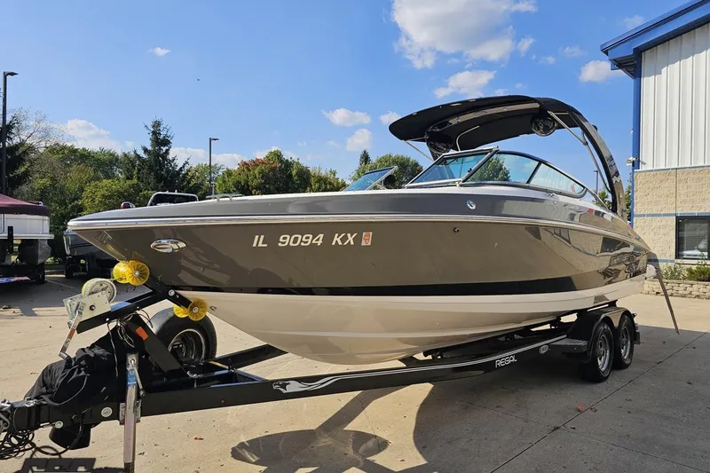Slide: The Image of 2018 Regal 2500 Bowrider boat on trailer, parked outdoors under a clear blue sky. - 19
