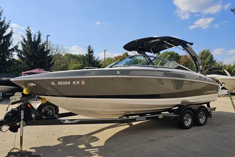 Slide: The Image of 2018 Regal 2500 Bowrider boat on trailer, parked outdoors under a clear sky. - 20