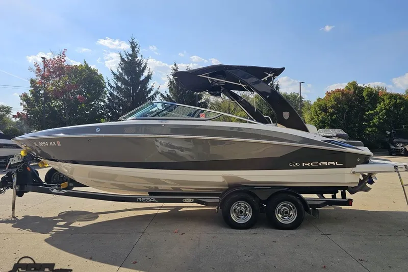 Slide: The Image of 2018 Regal 2500 Bowrider boat on trailer, parked outdoors under clear sky. - 22