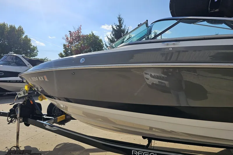 Slide: The Image of 2018 Regal 2500 Bowrider boat on trailer, sunny day, trees in background. - 23